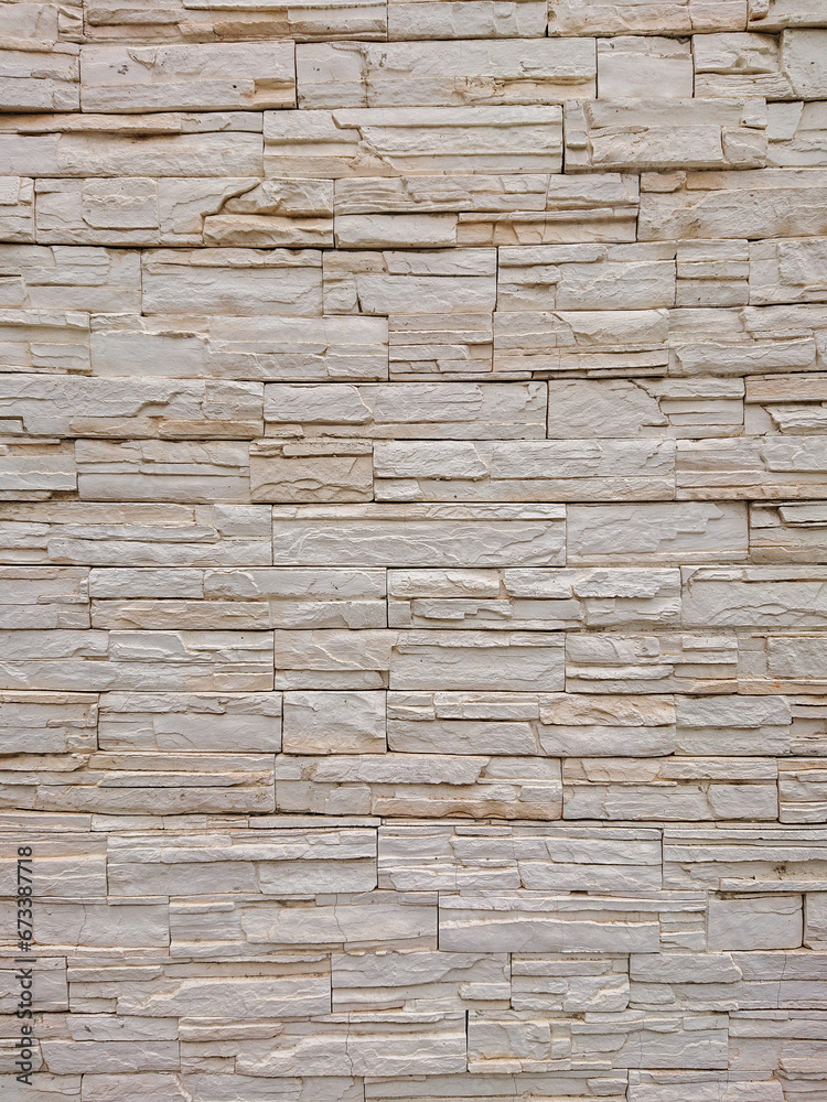 Beige stone wall vertical texture with stacked bricks, ideal for architectural backgrounds, home decor, and construction design Beige stone wall vertical texture with stacked bricks, ideal for architectural backgrounds, home decor, and construction design