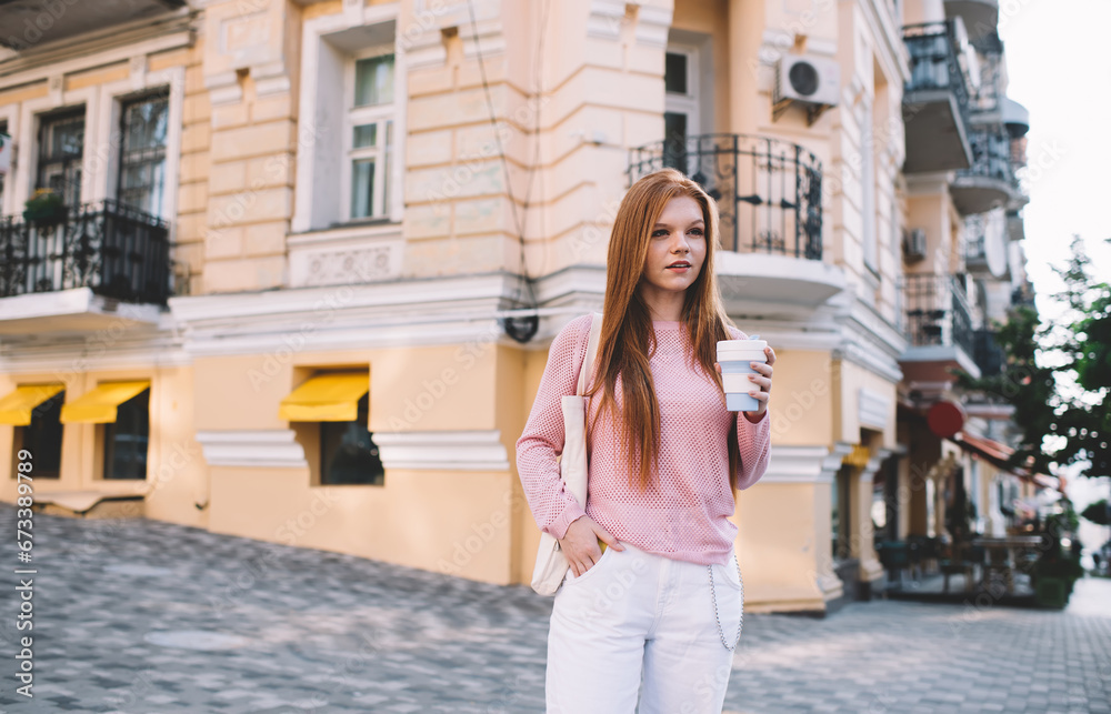 Happy woman standing with takeaway coffee on street