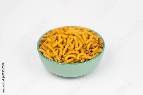 pasta horns in a green bowl on a white background