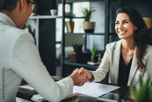 Happy mid aged business woman manager handshaking at office meeting. Smiling female hr hiring recruit at job interview, bank or insurance agent, lawyer making contract deal with client at work. photo