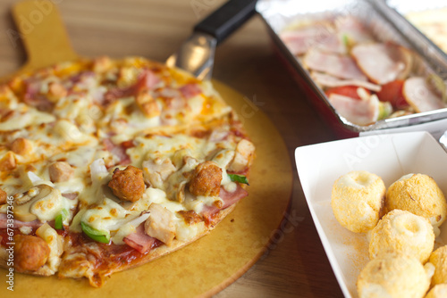 hawaiian pizza serve on wood tray with side dish Lasagna , spaghett , cheese ball