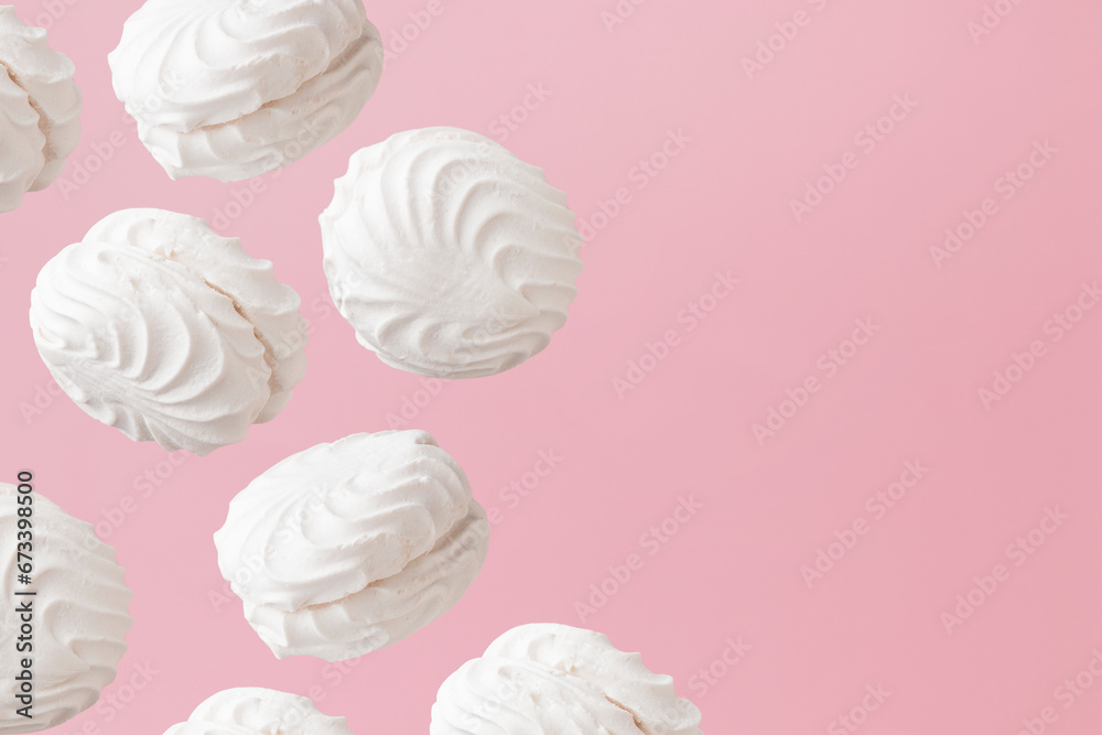 White zephyr marshmallows on light pastel pink background banner with an empty space White zephyr marshmallows on light pastel pink background banner with an empty space