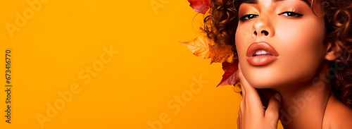 Detail shot of beautiful black woman with afro hair and autumn leaves. Beauty and cosmetics advertising concept.
