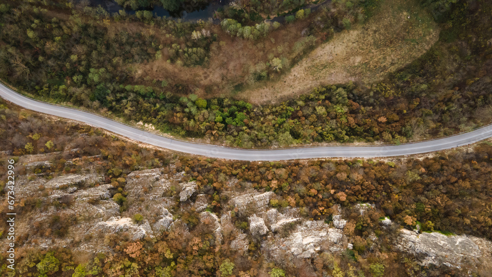 Top down aerial view drone image on the road trough the trees and forest in mountain range in autumn day in Serbia Travel journey and vacation concept