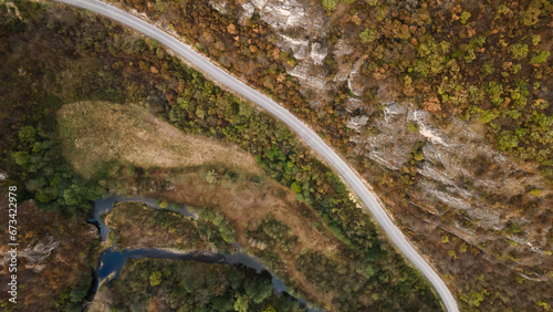 Top down aerial view drone image on the road trough the trees and forest in mountain range in autumn day in Serbia Travel journey and vacation concept