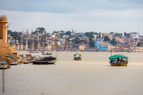 Woman looks the view of the Ganges with its boats, people and sacred water of Varanasi in India