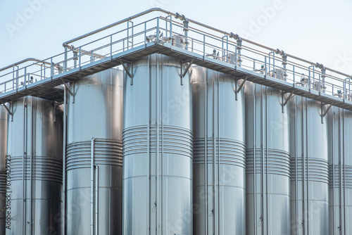 Stainless group vertical steel storage tanks for wine fermentation and maturation in modern winery factory production. Industrial and technology background