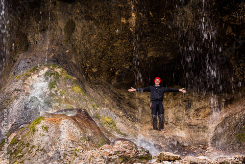 Overjoyed man in red hat enjoying Chegem waterfalls, Caucasus