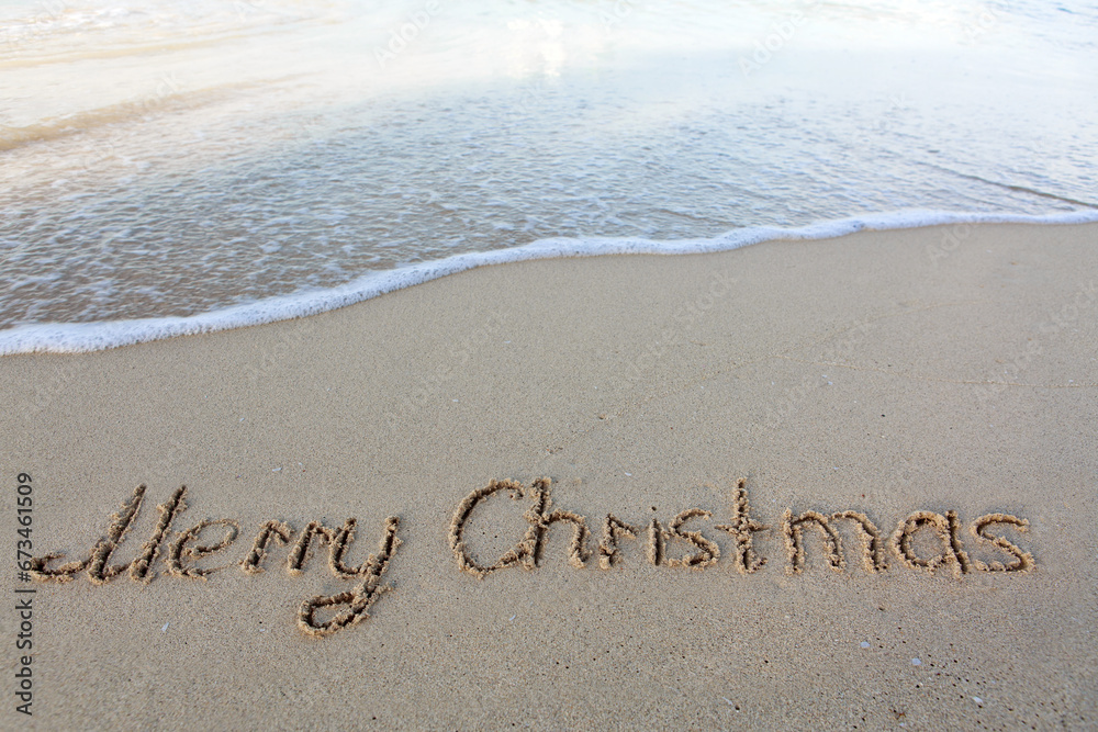 Fototapeta premium Merry Christmas text on the sea beach.