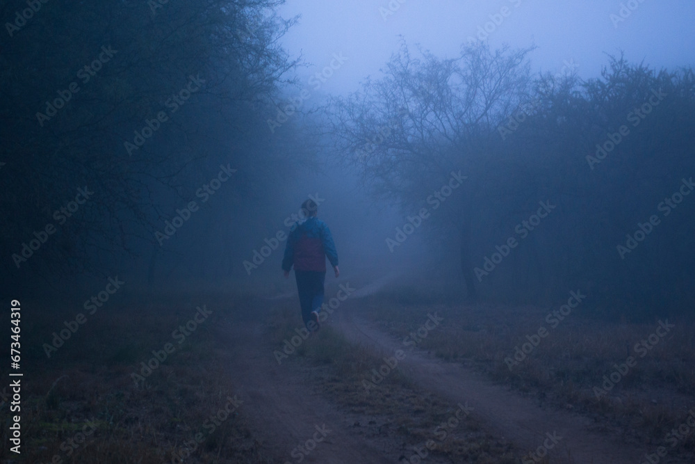 Girl walking through a path with blue soft mist
