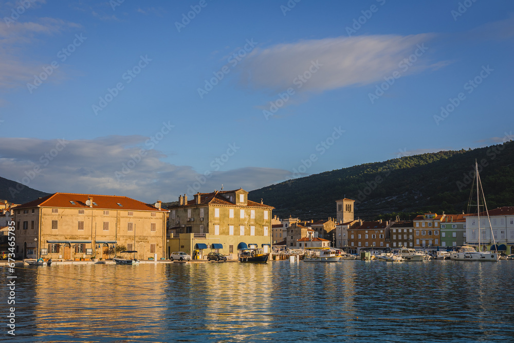 Central old part of the city of Cres viewed from the sea. Entry towards the old marina of Cres town in the islands of Croatia.