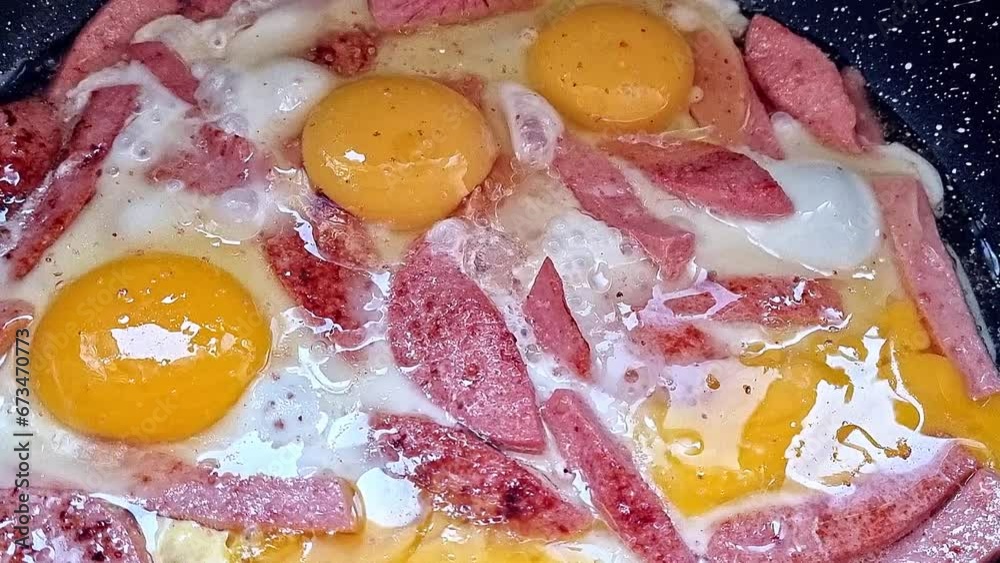 Close-up of eggs and sausage being fried in a frying pan. Close-up of eggs and sausage being fried in a frying pan.