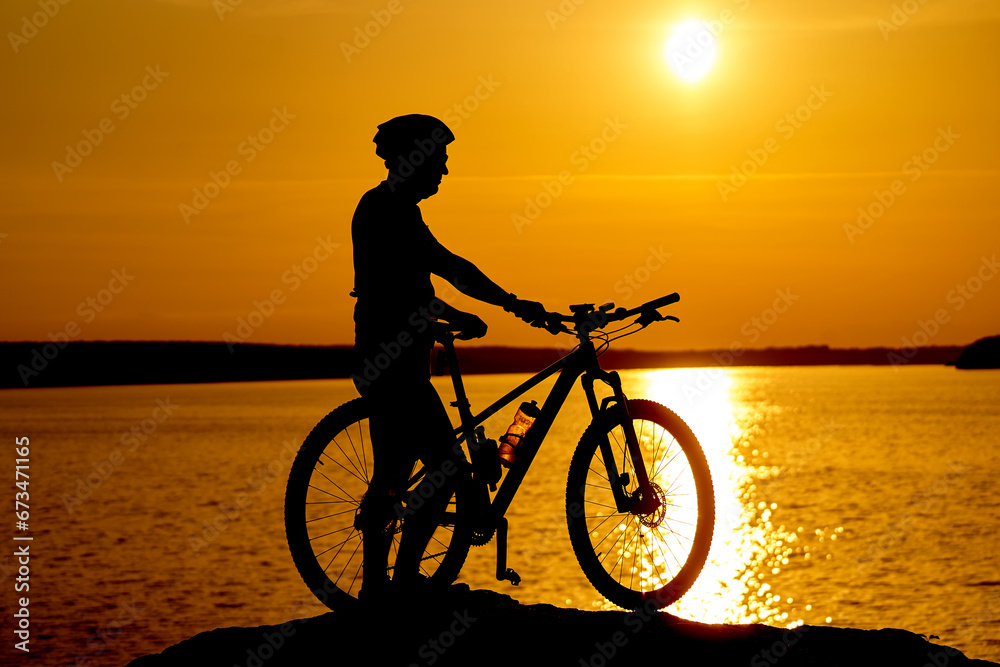 Fototapeta premium A Serene Beachscape With a Man and His Bicycle. A man standing next to a bike on top of a beach