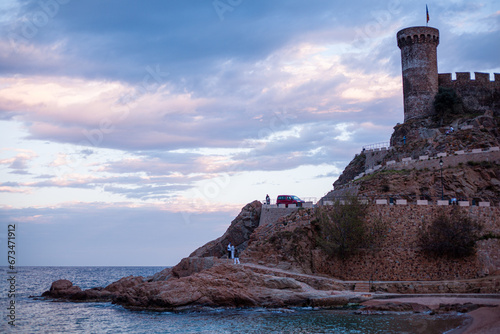 Tossa de mar, castello sulla spiaggia di Tossa e mare che si fondono insieme al tramonto.