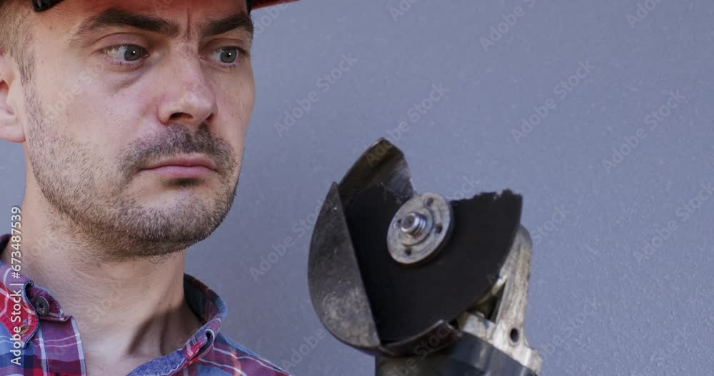 The mechanic takes off his safety glasses with a fragment of a cutting blade stuck in them