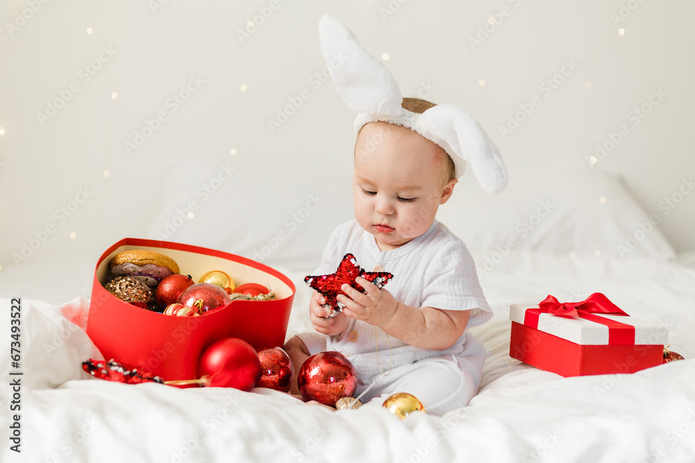 Adorable baby boy playing with Christmas baubles and new year gift. Winter holidays celebration and festive concept Adorable baby boy playing with Christmas baubles and new year gift. Winter holidays celebration and festive concept