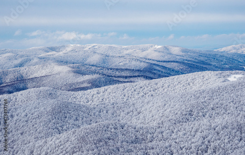 Fototapeta Naklejka Na Ścianę i Meble -  Winter mountain landscape. Snow-covered trees on mountain slopes. View from Mala Rawka to Beskid Range Montains.  Bieszczady Mountains. Poland.