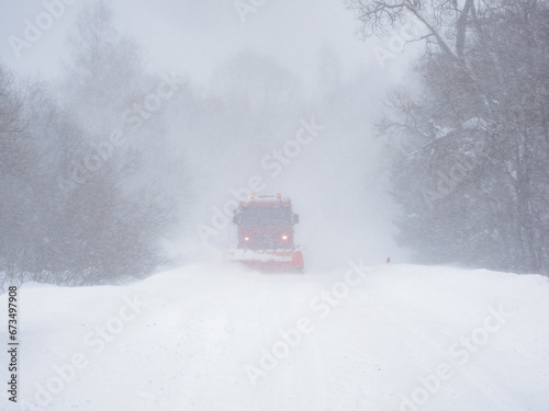 A snowplow clears a snow-covered road.