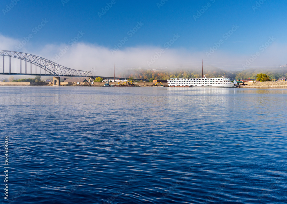 Upper Mississippi on calm misty morning at Dubuque with docked river cruise boat by Julien Dubuque Bridge