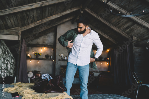 Stylish man putting on jacket