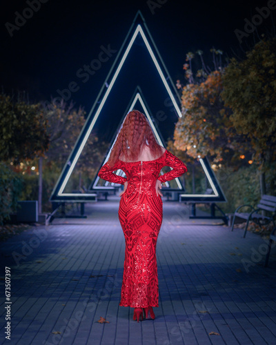 Woman in a red dress stands with her back
