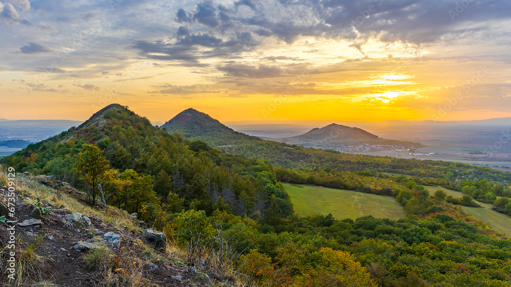 Sunset among the volcanic hills of the Bohemian Highlands, photographed from Brník hill, other hills are Srdov, Oblík and in the background is Raná peak