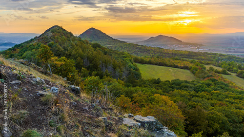 Sunset among the volcanic hills of the Bohemian Highlands  photographed from Brn  k hill  other hills are Srdov  Obl  k and in the background is Ran   peak