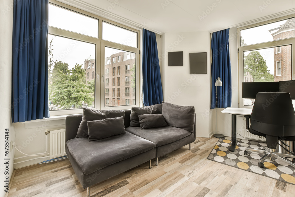 Obraz premium a living room with wood flooring and blue drapes hanging on the windows in the room is very spacious