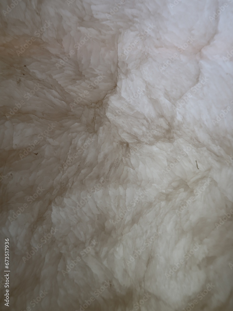Texture of nature alabaster stone wall in room.