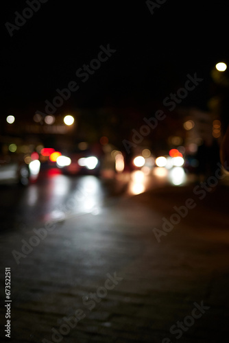 Out of focus view of cars passing at street level at night