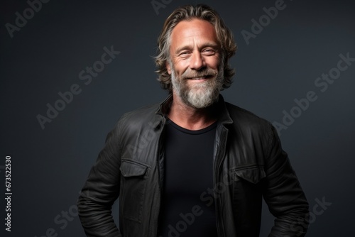 Handsome middle aged man with long gray hair and beard wearing a black leather jacket.