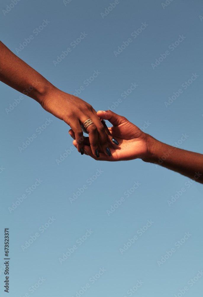 Black couple holding hands against blue sky Black couple holding hands against blue sky