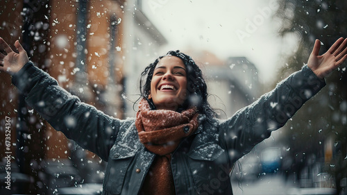 Woman smiling and raising hands in a snowfall