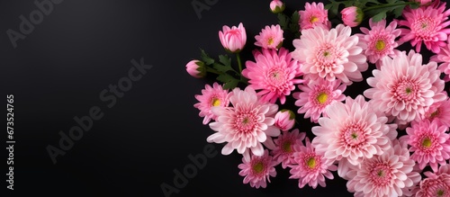 Fresh pink chrysanthemums and fern leaves create a beautiful bouquet while blooming in the background
