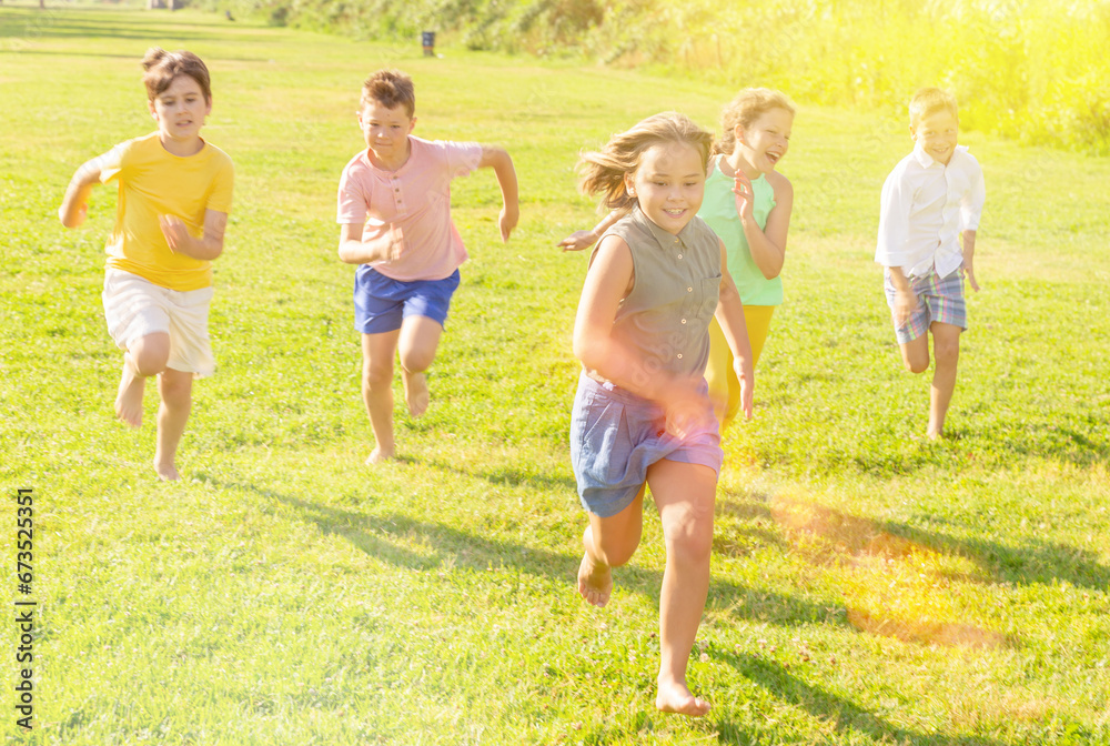 Cheerful children jogging together in the park and having fun