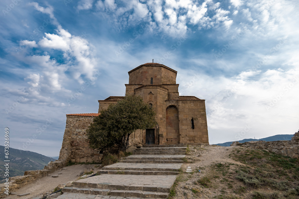 Jvari Monastery Georgian Orthodox  with city Mtskheta and clouds on blue sky