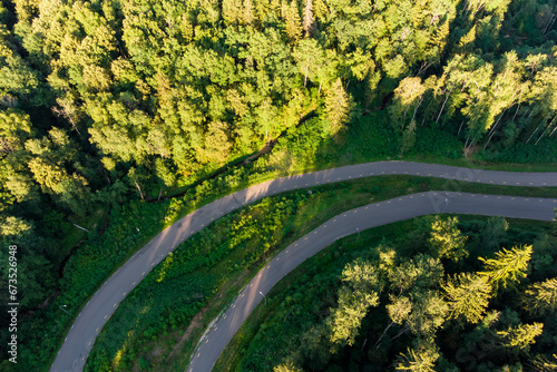 Asphalt road running through a forested area, aerial view. Roller ski track for training