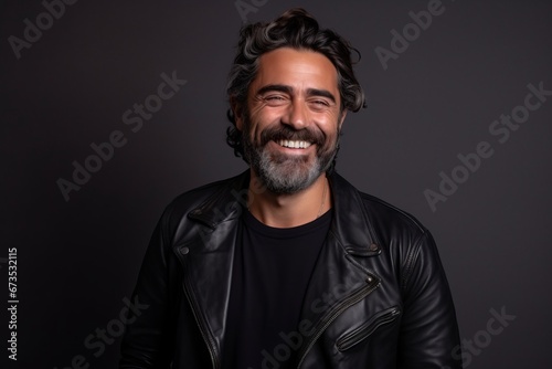 Portrait of a handsome man with beard and mustache wearing black leather jacket.