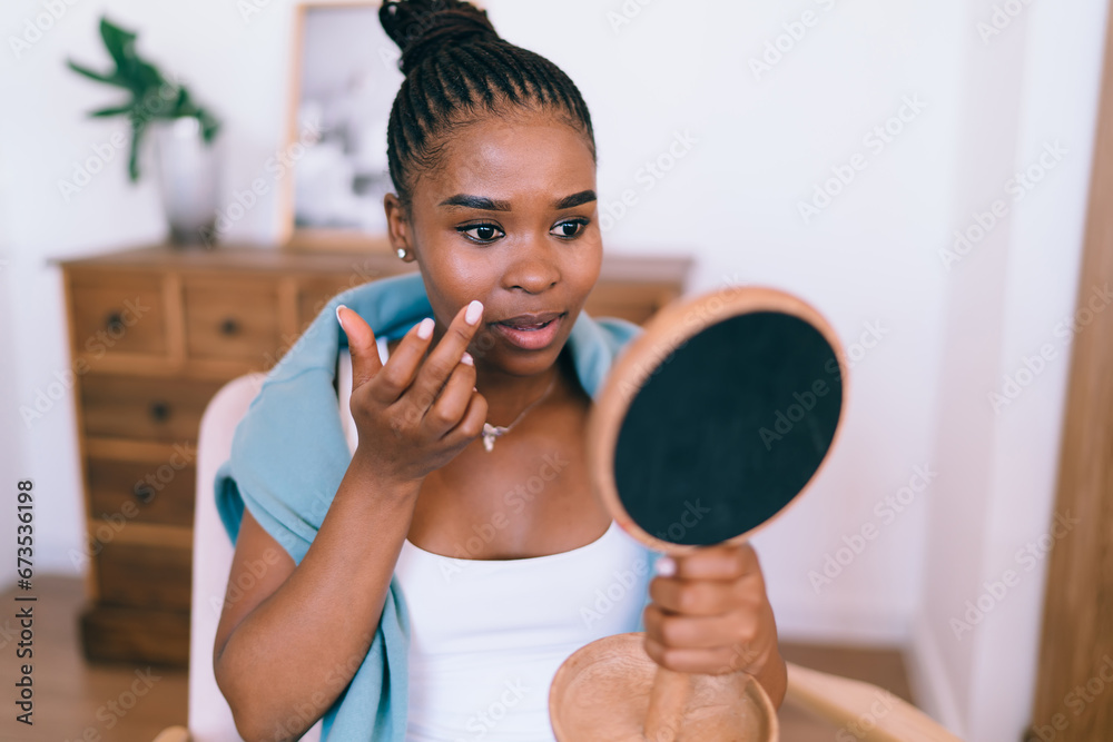 Black woman with wooden handheld mirror doing makeup Black woman with wooden handheld mirror doing makeup