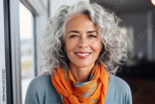portrait of happy senior woman in scarf looking at camera at home photo