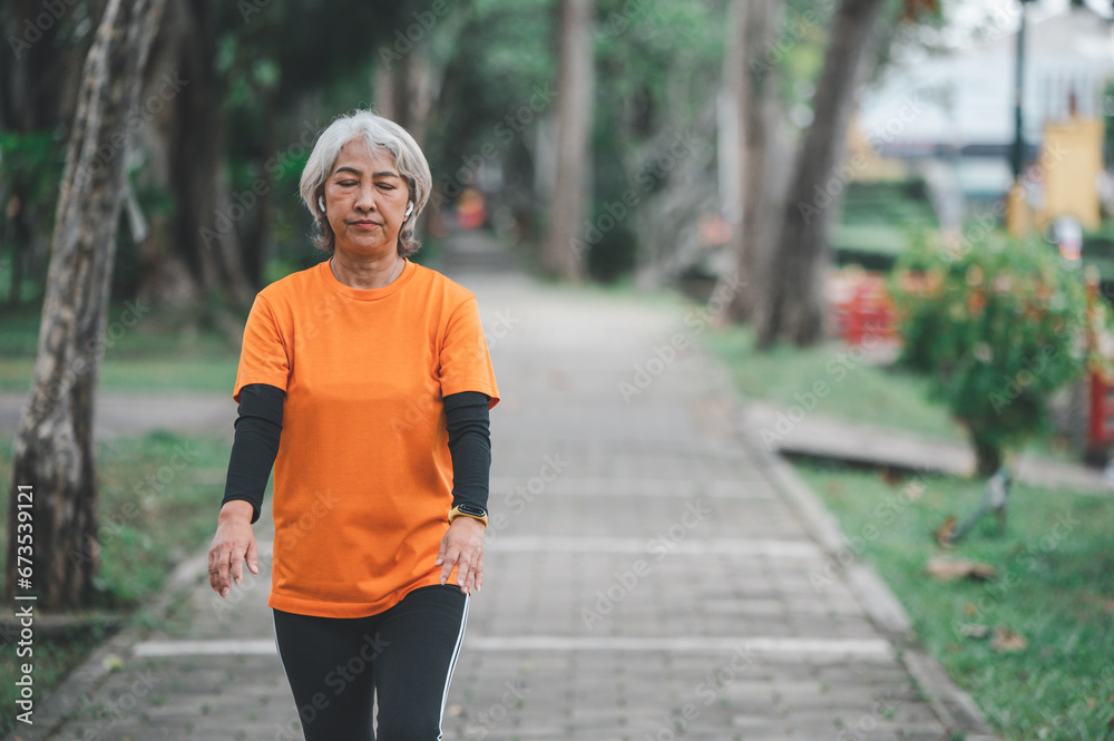 white-haired elderly person exercising in the park early in the morning. white-haired elderly person exercising in the park early in the morning.