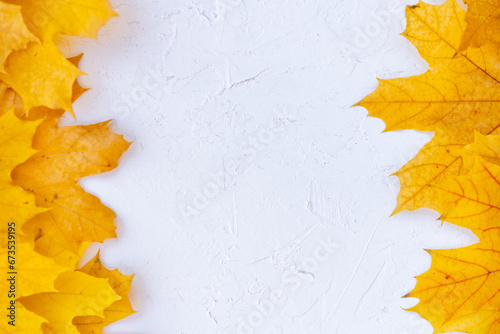Autumn leaves frame left right side white structured background top view Fall Border yellow and Orange Leaves vintage background table Copy space. Mock up for your design. Display for product or text