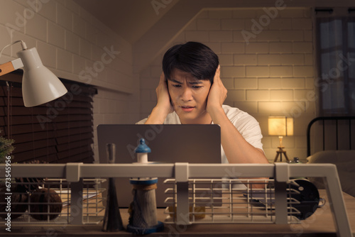 Asian freelancer feeling overwhelmed and stressed working overtime during nightshift photo