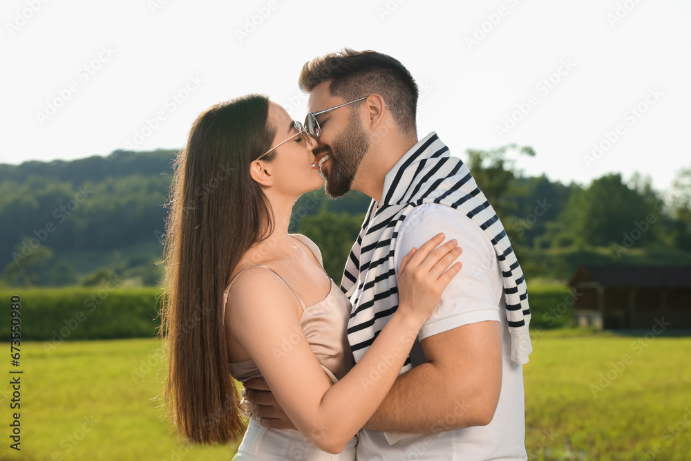Romantic date. Beautiful couple kissing in park on sunny day Romantic date. Beautiful couple kissing in park on sunny day