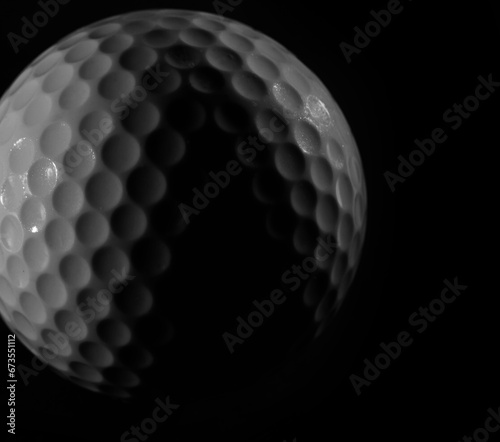 Golf ball macro detail on black background
