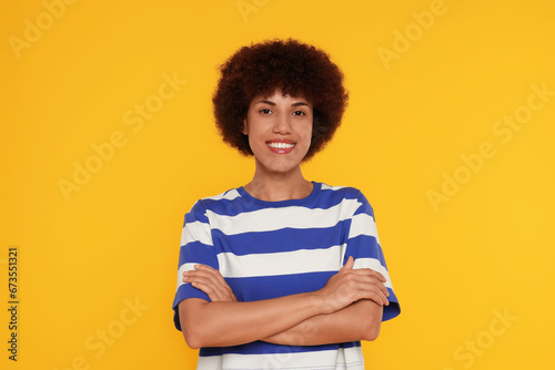 Portrait of happy young woman on orange background