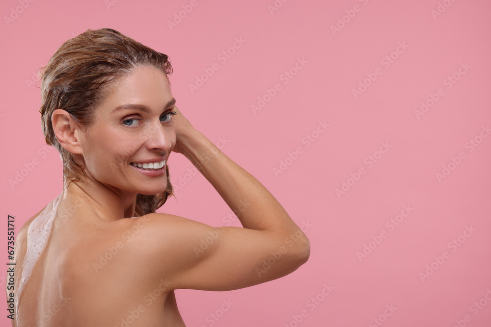 Beautiful happy woman washing hair on pink background. Space for text Beautiful happy woman washing hair on pink background. Space for text