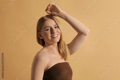 Beautiful young woman posing on beige background