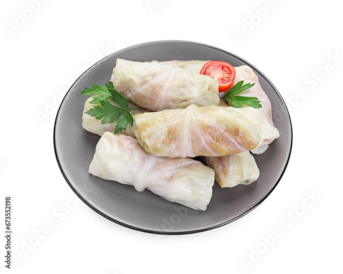 Plate with Uncooked stuffed cabbage rolls, tomato and parsley isolated on white