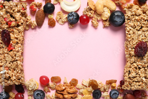 Frame made of tasty granola bars and ingredients on pink background, top view. Space for text